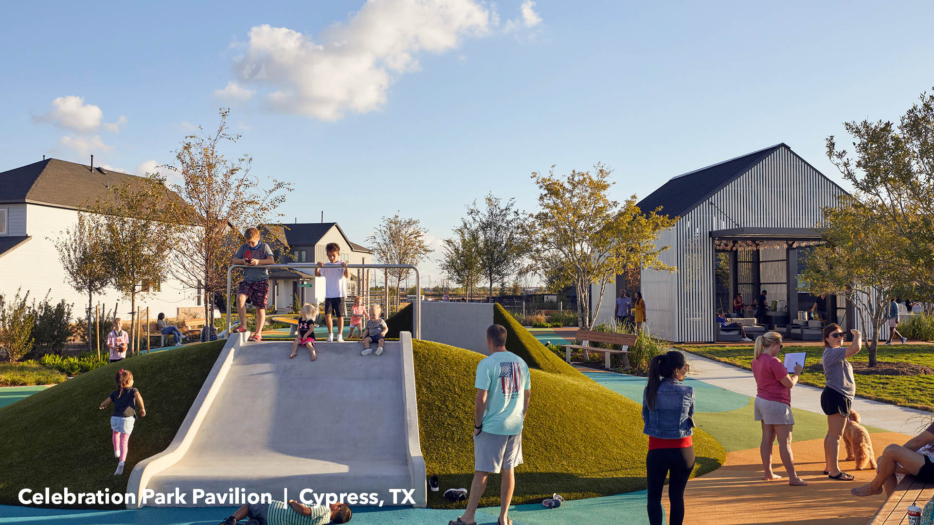 Kids playing on green mound and slide